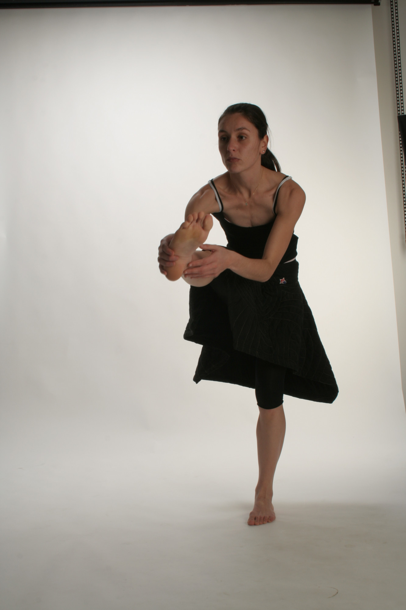 Female dancer in a black dress standing on one leg
