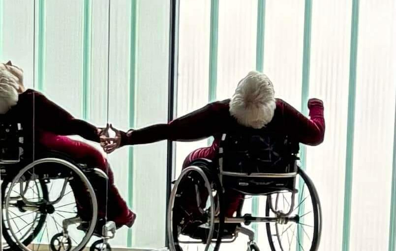 Image of a woman in a wheelchair with her back to the camera, arching her body backwards.