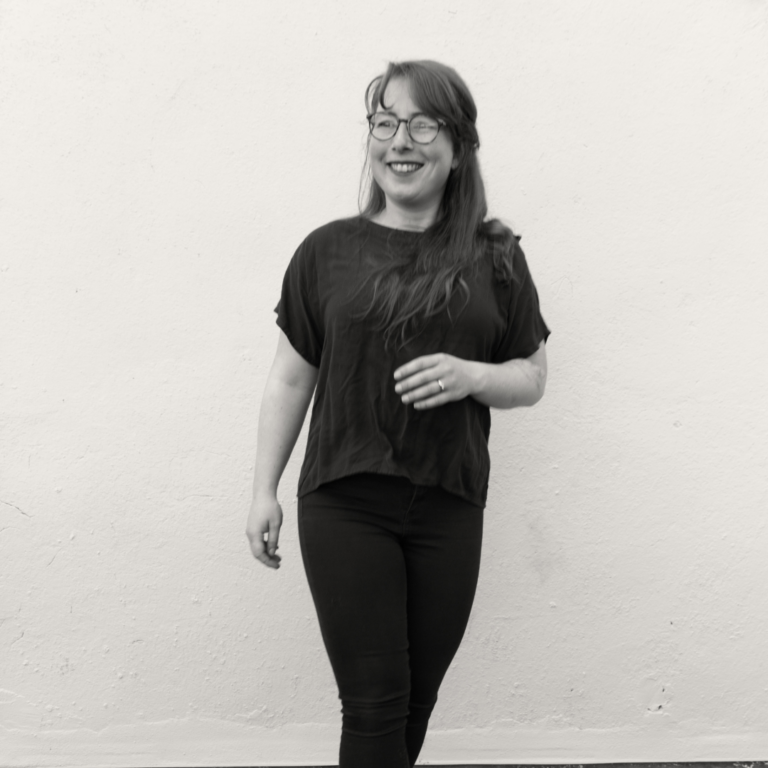 lack and white image of a woman standing against a light background.