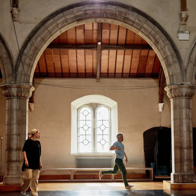 Image showing the inside of a church with a big arch and two dancers running.